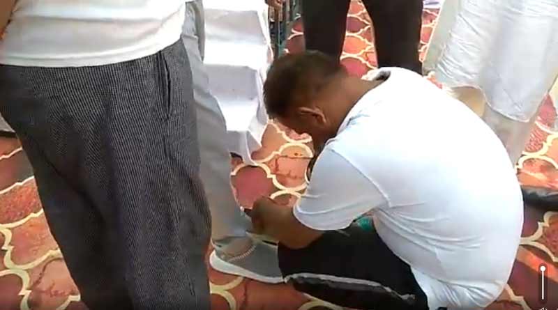 UP: Laxmi Narayan gets his shoelace tied by a government employee