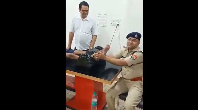 A senior police officer is seen massaging the feet of a Kanwar Yatra pilgrim