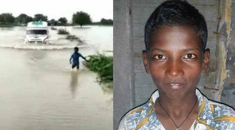 A boy guides ambulance over flooded bridge in Karnataka