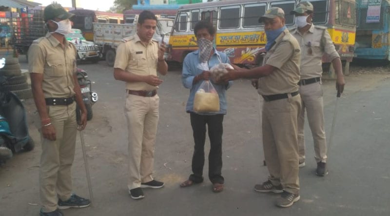 A police officer distributes rice, oil, potatoes for poor people