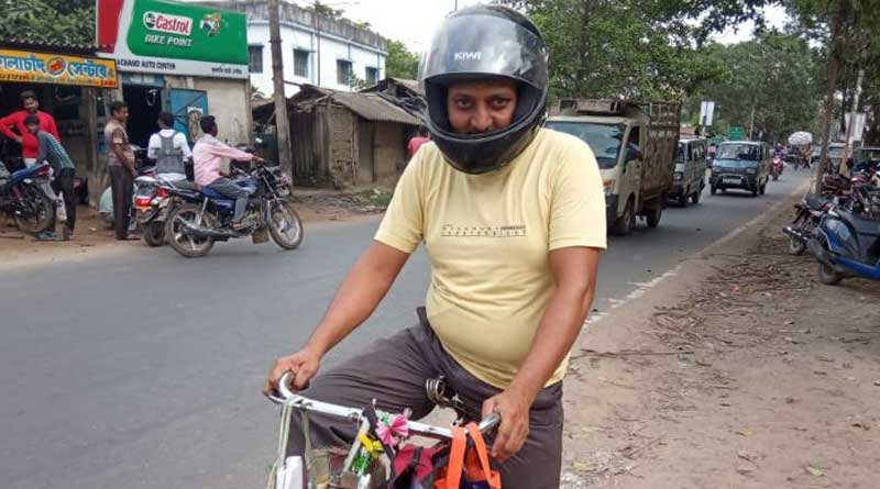 Bengali News: A newspaper seller in Burdwan wears helmet to protect himself against coronavirus | Sangbad Pratidin
