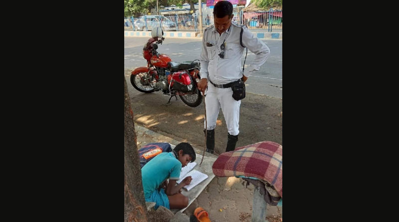 Traffic Sergeant of Kolkata Police Prakash Ghosh teaches a boy beside road । Sangbad Pratidin